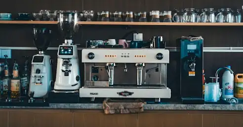 An espresso machine and two grinders along the roastery counter.